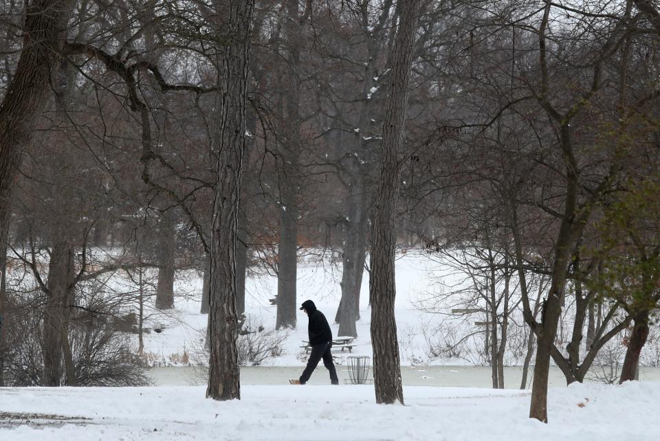 A visitor walks on the track at a nearly-deserted Bellevue State Park as the tail end of a winter storm passes through north Delaware, Saturday, Jan. 29, 2022.