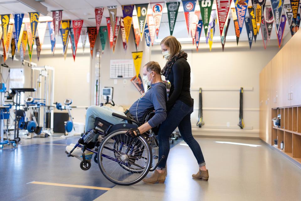 Craig Hospital physical therapist Allie Hamilton works with Dr. Jason Kolb, an Akron doctor who was injured in a skiing accident, on popping a wheelie and finding his balance point in his manual wheelchair.