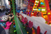 Children inspect the holiday windows display at the Macy's flagship store, Friday, Nov. 20, 2020, in New York. Macy's 2020 holiday windows honors essential workers and first responders during the coronavirus pandemic. (AP Photo/Mary Altaffer)