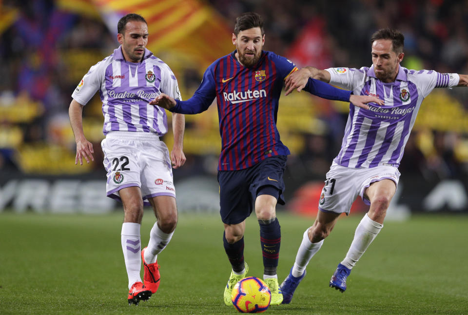 Barcelona forward Lionel Messi, center, challenges for the ball with Valladolid's Nacho Martinez, left, and Michel Herrero during the Spanish La Liga soccer match between FC Barcelona and Valladolid at the Camp Nou stadium in Barcelona, Spain, Saturday, Feb. 16, 2019. (AP Photo/Manu Fernandez)