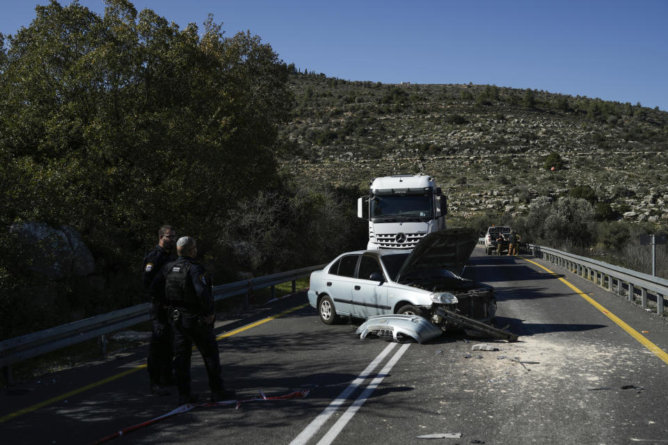 Israeli security forces examine the scene of a Palestinian shooting attack, near Wadi al-Haramiya, West Bank, Sunday, Jan. 7, 2024. A Palestinian resident of Jerusalem who presumably was mistaken by the assailants as an Israeli because of the Israeli car license plates was fatally shot in the shooting, the Magen David Adom rescue service said. (AP Photo/Leo Correa)