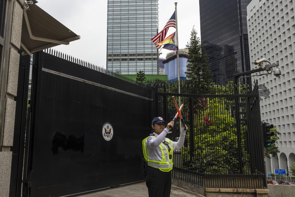 A security guard stands outside the Consulate General of the United States after it was vandalized with graffiti in Hong Kong, Tuesday, June 13, 2023. Hong Kong police on Tuesday arrested a man who allegedly spray-painted graffiti on the wall and gate of the U.S. consulate, according to media reports and the police. (AP Photo/Louise Delmotte)
