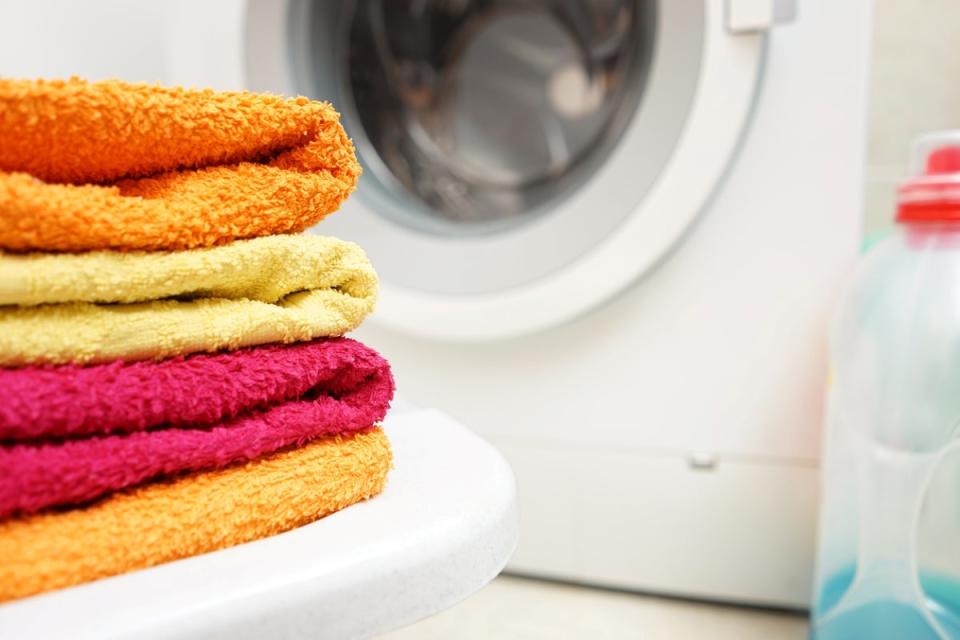 Red, yellow, and orange towels on table in laundry room