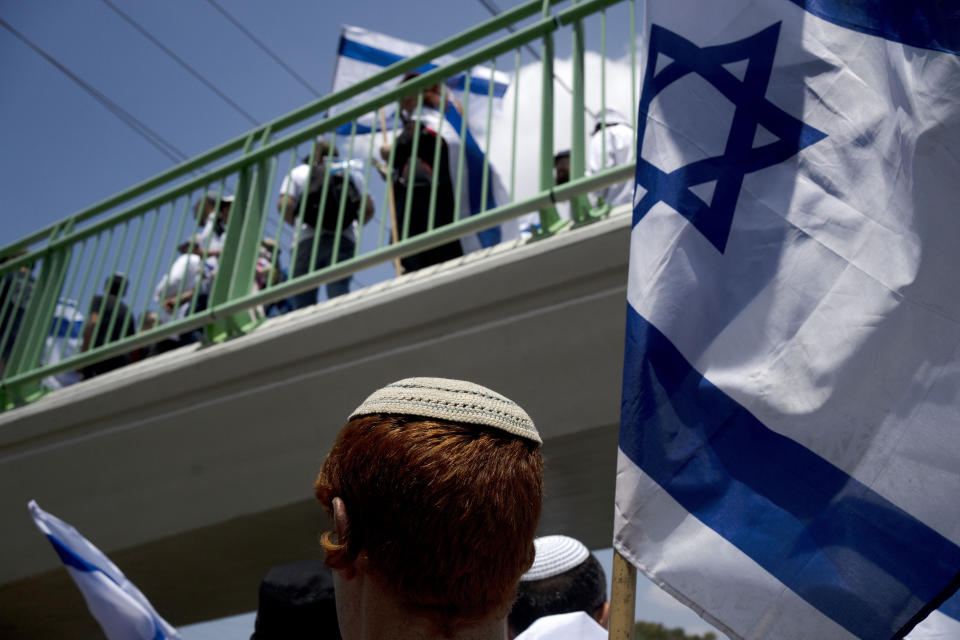 Israelis march with national flags in the southern city of Sderot calling for Israel to reoccupy the Gaza Strip once the war is over, Tuesday, May 14, 2024. (AP Photo/Maya Alleruzzo)