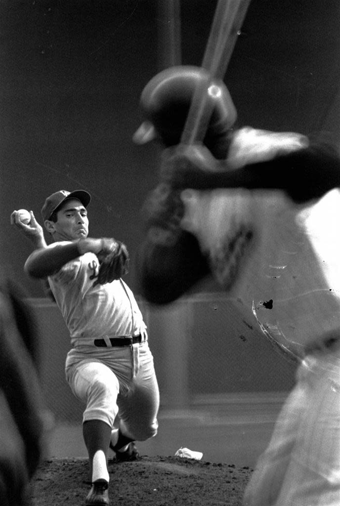 Lefthander Sandy Koufax cocks his hand to let go with a pitch in the final World Series game, October 14, 1965, at Metropolitan Stadium, in Minneapolis, Minnesota. The Los Angeles Dodgers' hurler is opposed by Minnesota Twins' pitcher Jim Kaat.