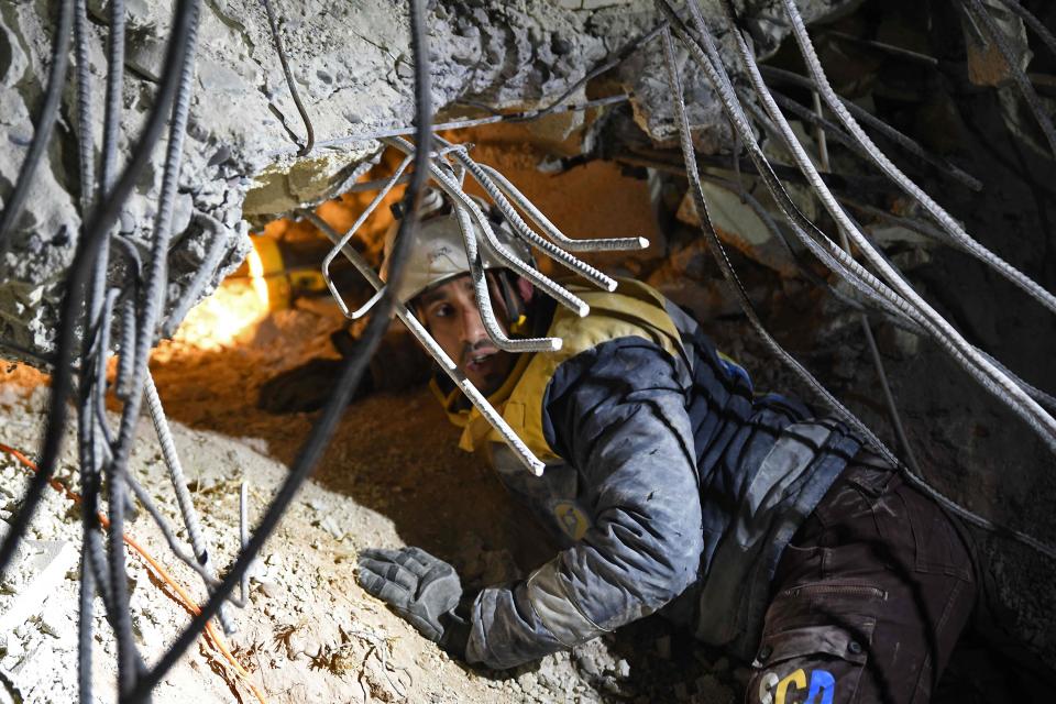 A member of the White Helmets, works on a collapsed building the evening of February 7, 2023, in the town of Jandairis.