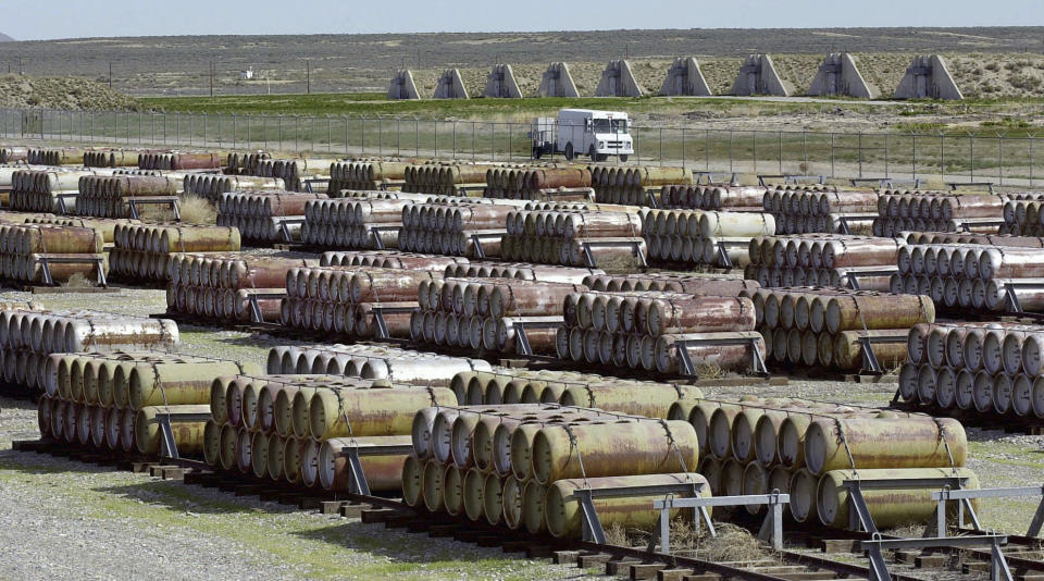 FILE - This April 30, 2001 file photo shows a safety vehicle passing a compound filled with 170-gallon containers of mustard and blister agent at the Deseret Chemical Depot in Tooele, Utah. At rear, igloos house GB nerve gas and other chemical weapons. (AP Photo/Douglas C. Pizac, File)