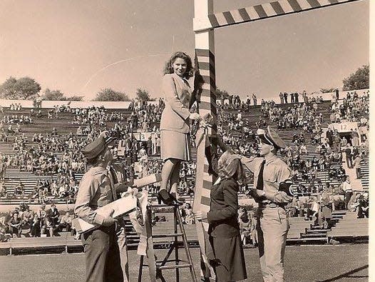 A black and white photograph of Marta Fainberg at a college football game.