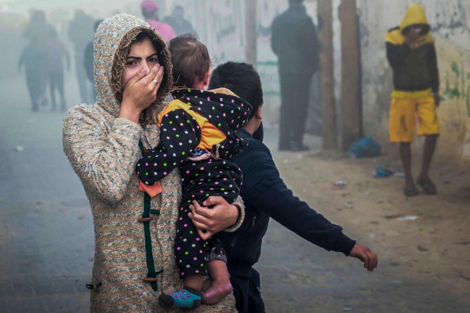 A woman and child flee an Israeli strike in Rafah in southern Gaza on Thursday (AFP via Getty Images)