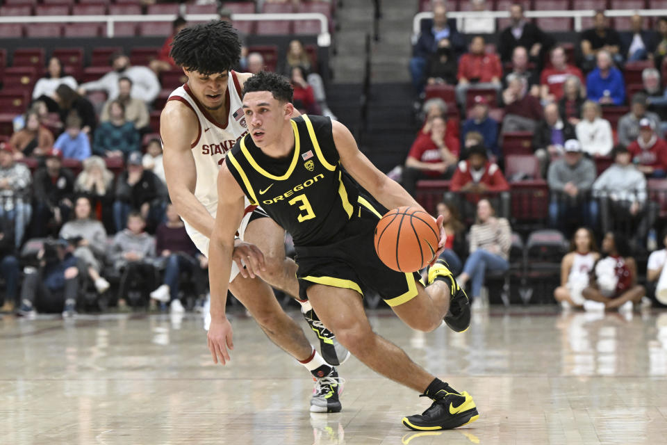 Oregon guard Jackson Shelstad (3) dribbles the ball around Stanford forward Spencer Jones during the second half of an NCAA college basketball game Thursday, Feb. 22, 2024, in Stanford, Calif. (AP Photo/Nic Coury)