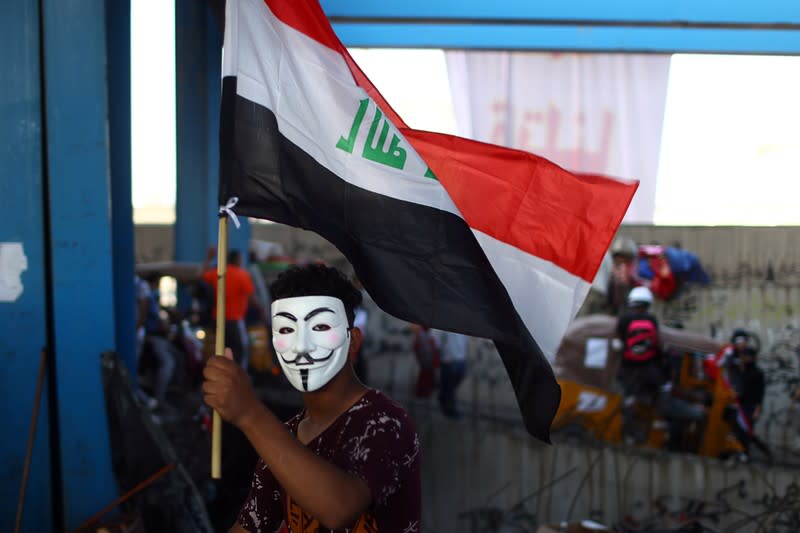 An Iraqi demonstrator holds a flag inside the high-rise building, called by Iraqi the Turkish Restaurant Building, during anti-government protests in Baghdad