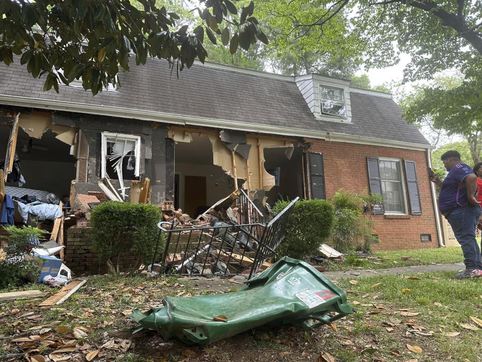 Debris covers the lawn of a home from Monday's standoff with police in Charlotte, N.C. on Tuesday, April 30, 2024. Police in North Carolina say a shootout that killed four law enforcement officers and wounded four others began as officers approached the home to serve a warrant for a felon wanted for possessing a firearm. (AP Photo/Jeffrey Collins)