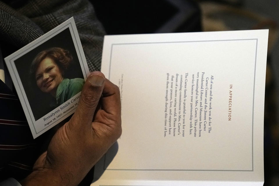 A guest holds a program before a repose service for former first lady Rosalynn Carter takes place in the lobby of the Jimmy Carter Presidential Library and Museum in Atlanta, Monday, Nov. 27, 2023. (AP Photo/Brynn Anderson, Pool)