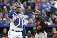 Baltimore Orioles' Anthony Santander, right, runs past Kansas City Royals catcher Salvador Perez, left, to score on a two-run single by Jordan Westburg during the second inning of a baseball game Saturday, April 20, 2024, in Kansas City, Mo. (AP Photo/Charlie Riedel)