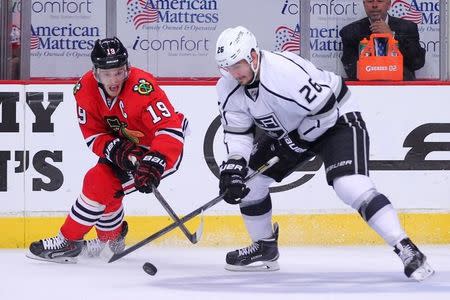 Chicago Blackhawks center Jonathan Toews (19) steals the puck from Los Angeles Kings defenseman Slava Voynov (26) during the second period in game seven of the Western Conference Final of the 2014 Stanley Cup Playoffs at the United Center. Jun 1, 2014; Chicago,USA;Dennis Wierzbicki-USA TODAY Sports