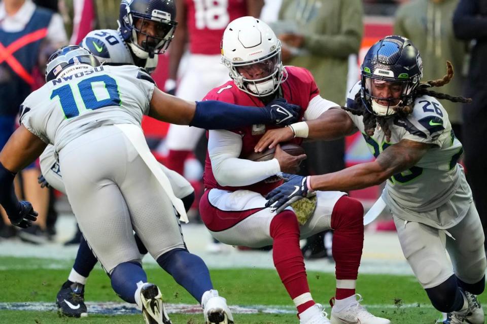 Arizona Cardinals quarterback Kyler Murray (1) is tackled between Seattle Seahawks linebacker Uchenna Nwosu (10) and safety Ryan Neal (26) during the first half of an NFL football game in Glendale, Ariz., Sunday, Nov. 6, 2022. (AP Photo/Matt York)