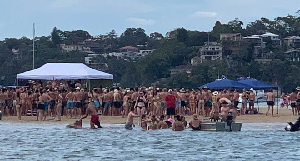 Dozens of people gather on a sandbar in Lilli Pilli to celebrate Australia Day, before the party was shut down by police.