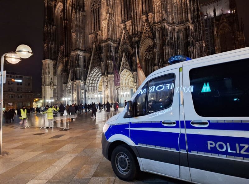 A police vehicle is parked in front of the cathedral. According to dpa, security authorities have received information about a possible plan by an Islamist group to attack Cologne Cathedral. Sascha Thelen/dpa