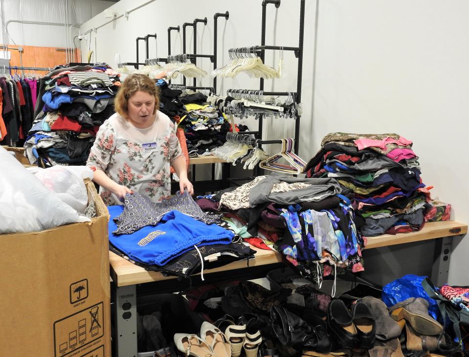 Heather Little sorts through clothing donations at the new Coshocton Goodwill at 310 Whitewoman St.