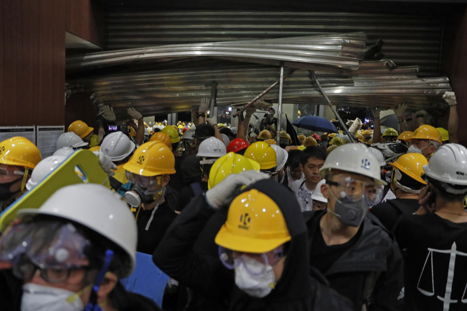 Protesters break into the Legislative Council in Hong Kong, Monday, July 1, 2019. Protesters in Hong Kong took over the legislature's main building Friday night, tearing down portraits of legislative leaders and spray painting pro-democracy slogans on the walls of the main chamber.(AP Photo/Kin Cheung)