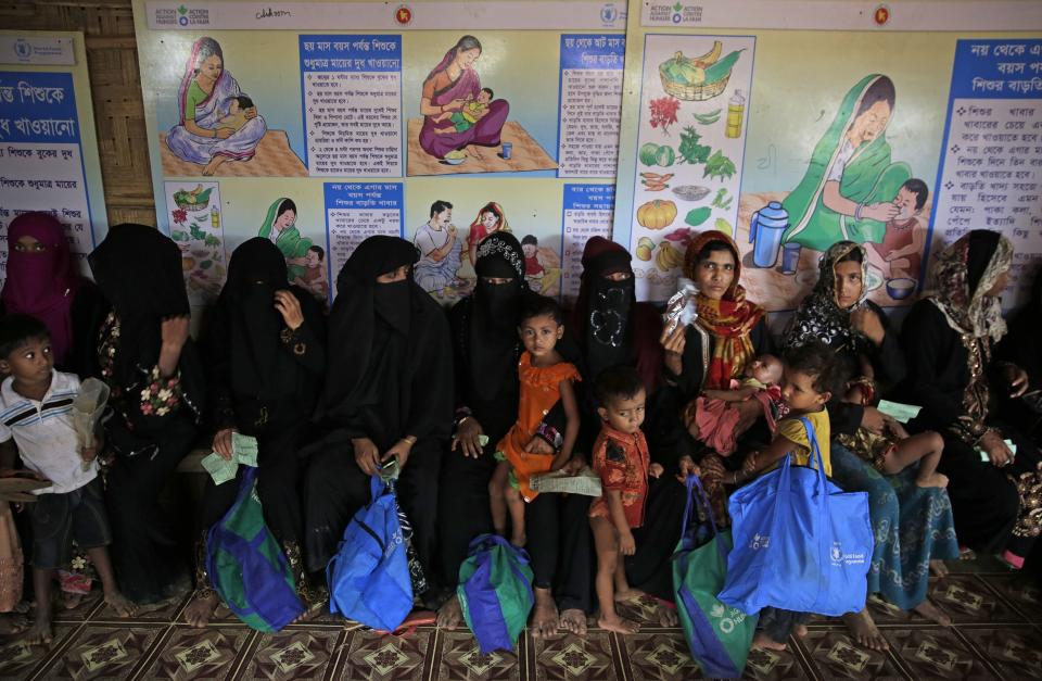 In this photograph taken Aug. 24, 2018, Rohingya refugees wait at a U.N. World Food Programme (WFP) facility to receive food supplements for their children in Kutupalong refugee camp, Bangladesh. Faith healers have long been sought out in Rohingya society to treat physical and mental ailments. Their trade has thrived in part because of traditional beliefs and in part because Rohingya have lacked access to modern medical care in Buddhist-majority Myanmar, where they are one of the most persecuted minority groups in the world. Access to medical care has changed for the better in the refugee camps in Bangladesh, yet many Rohingya still seek out their faith healers. (AP Photo/Altaf Qadri)