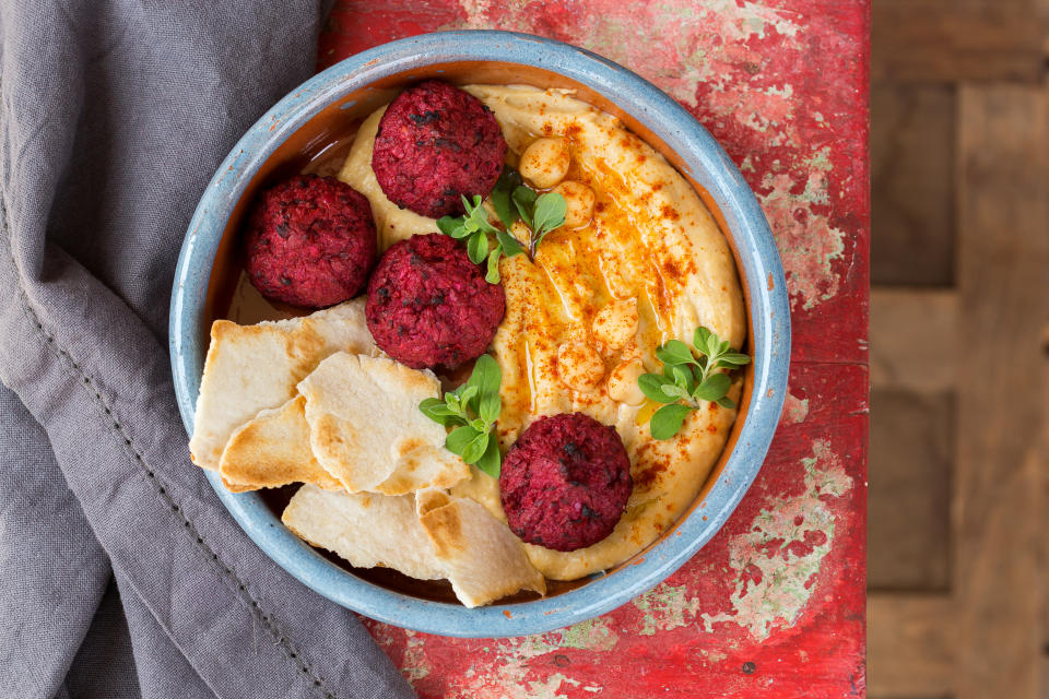 Chickpea hummus and beetroot falafel with olive oil, paprika and pita bread. Plating, healthy snacking. Traditional jewish and middle eastern food