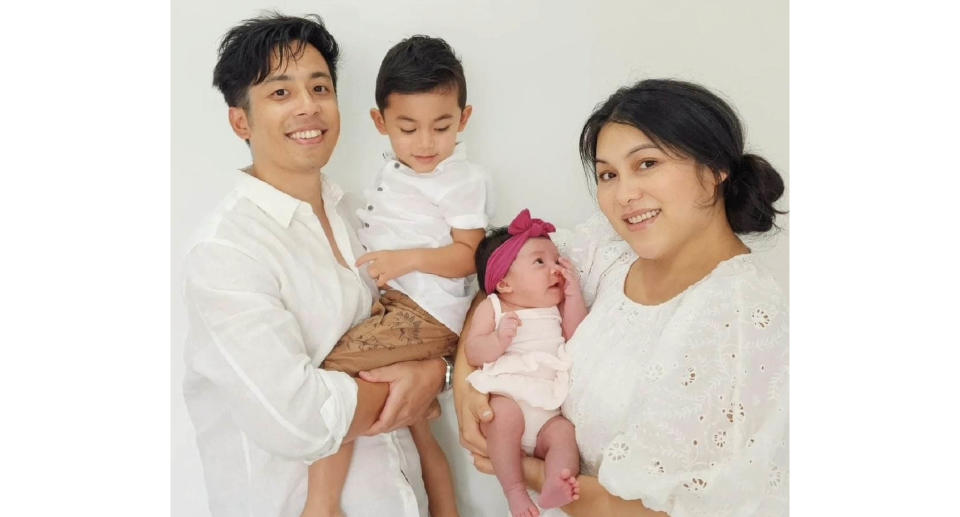 Ian Prahastono holding his son and Katrina Sila holding their baby girl.