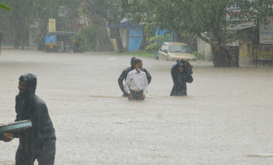 People wade through floodwaters in Kolhapur, in the western Indian state of Maharashtra, Friday, July 23, 2021. Landslides triggered by heavy monsoon rains hit parts of western India, killing more than 30 people and leading to the overnight rescue of more than 1,000 other people trapped by floodwaters, officials said Friday. (AP Photo)
