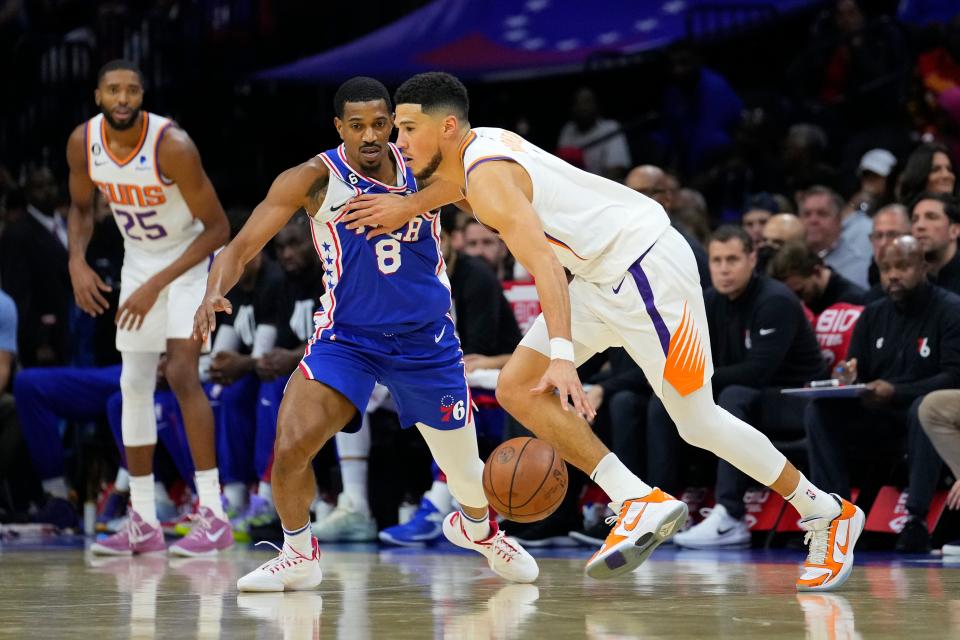 Phoenix Suns' Devin Booker, right, drives past Philadelphia 76ers' De'Anthony Melton during the first half of an NBA basketball game, Monday, Nov. 7, 2022, in Philadelphia. (AP Photo/Matt Slocum)