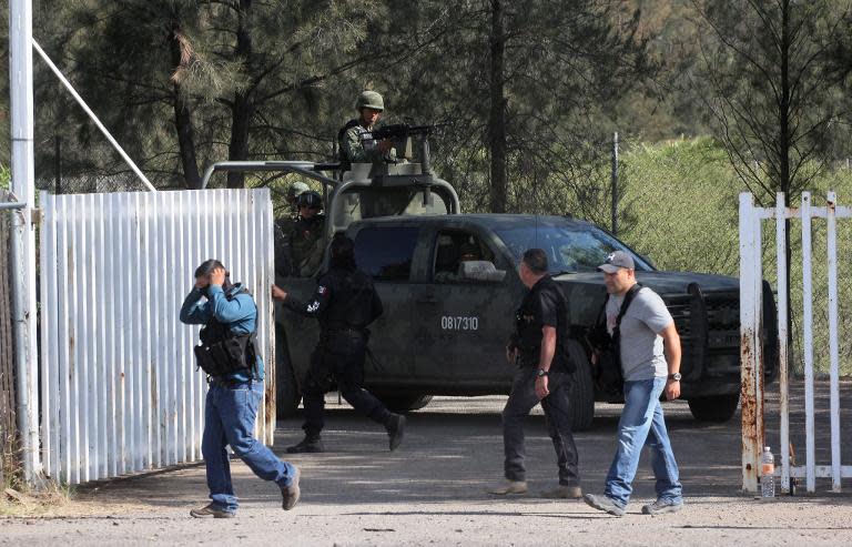 Police and soldiers patrol the ranch where gunmen took cover during an intense gun battle with police, along the Jalisco-Michoacan highway in Vista Hermosa, Michoacan State, on May 22, 2015