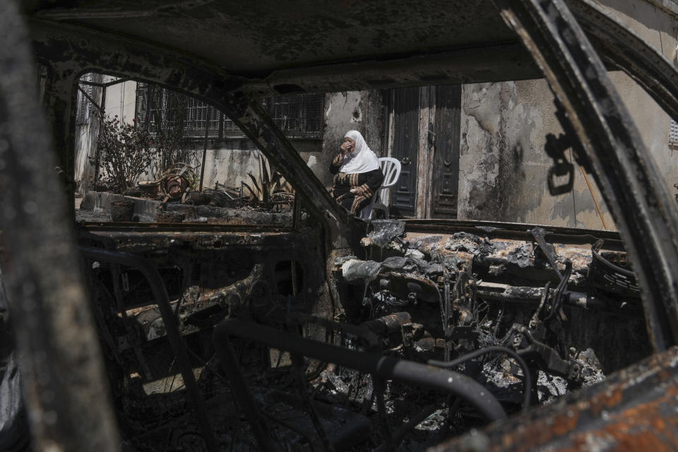 A Palestinian woman sits outside her torched home, days after it was set on fire by Jewish settlers, in the West Bank town of Turmus Ayya, Saturday, June 24, 2023. Israeli settlers entered the town, setting fire to Palestinian cars and homes after four Israelis were killed by Palestinian gunmen in the northern West Bank on Tuesday. (AP Photo/Mahmoud Illean)