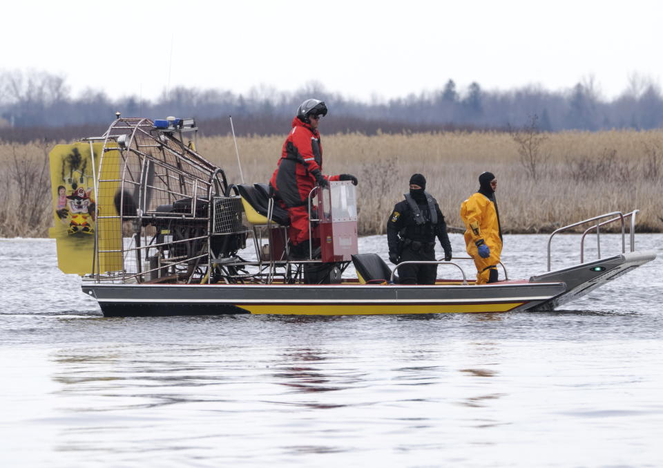 Searchers look for victims in Akwesasne, Quebec, Friday, March 31, 2023. Authorities in the Mohawk Territory of Akwesasne said Friday one child is missing after the bodies of six migrants of Indian and Romanian descent were pulled from a river that straddles the Canada-U.S. border. (Ryan Remiorz/The Canadian Press via AP)