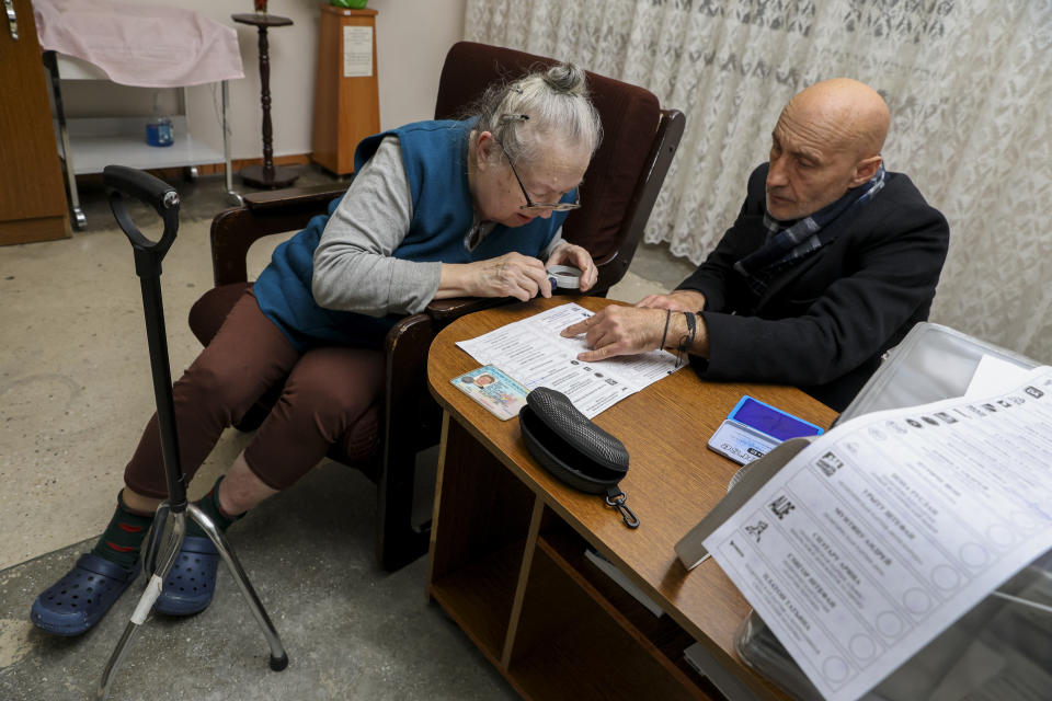 An elderly Moldovan woman looks at the ballot before casting her vote in a mobile urn at a hospital, during local elections in Chisinau, Moldova, Sunday, Nov. 5, 2023. Moldovans will cast ballots in nationwide local elections on Sunday amid claims by Moldovan authorities that Russia has been conducting a "hybrid warfare" to undermine the vote in the European Union candidate country. (AP Photo/Aurel Obreja)