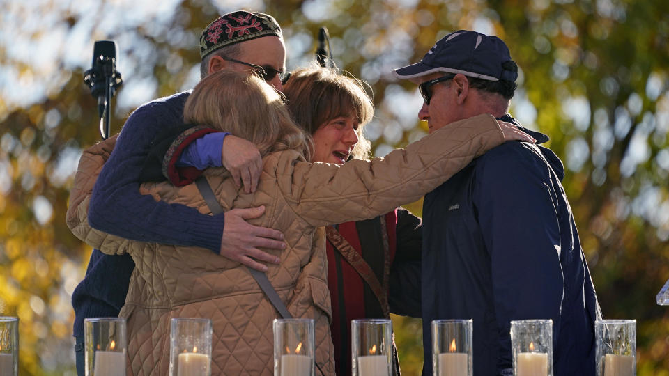 FILE - People embrace after lighting a candle in memory of Melvin Wax, one of 11 worshippers killed four years ago when a gunman opened fire at the Tree of Life synagogue in the Squirrel Hill neighborhood, during a commemoration ceremony in Pittsburgh on Thursday, Oct. 27, 2022. (AP Photo/Gene J. Puskar,File)