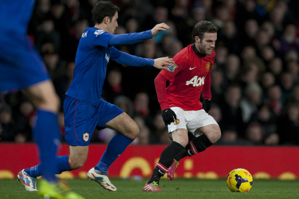 Manchester United's Juan Mata, right, keeps the ball from Cardiff City's Peter Whittingham during their English Premier League soccer match at Old Trafford Stadium, Manchester, England, Tuesday Jan. 28, 2014. (AP Photo/Jon Super)