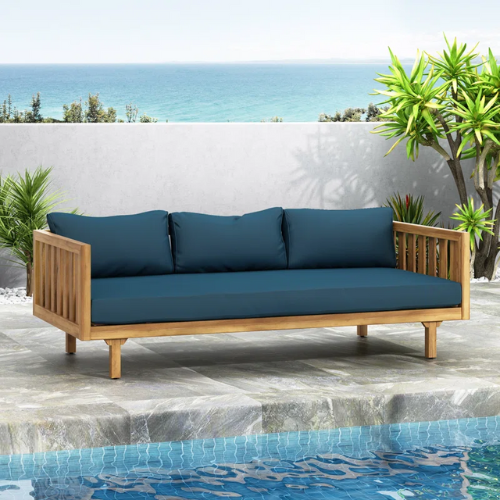 teal blue outdoor sofa poolside on patio overlooking the ocean