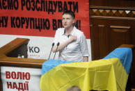 <p>Ukrainian pilot Nadiya Savchenko, who spent two years as a Russian prisoner, sings the national anthem during the parliament session in Kiev, Ukraine, Tuesday, May 31, 2016. Savchenko appeared for her first session at the Ukrainian parliament as a lawmaker in former Prime Minister Yulia Tymoshenko’s party on Tuesday. The poster reads: “Freedom to Nadezhda Savchenko.”(AP Photo/Efrem Lukatsky) </p>