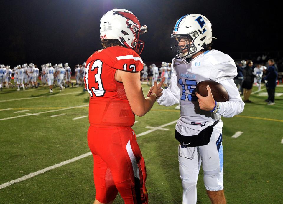 Milford High School quarterback Evan Cornelius (left) speaks with Franklin High School quarterback Jared Arone after the game, October 29, 2021.