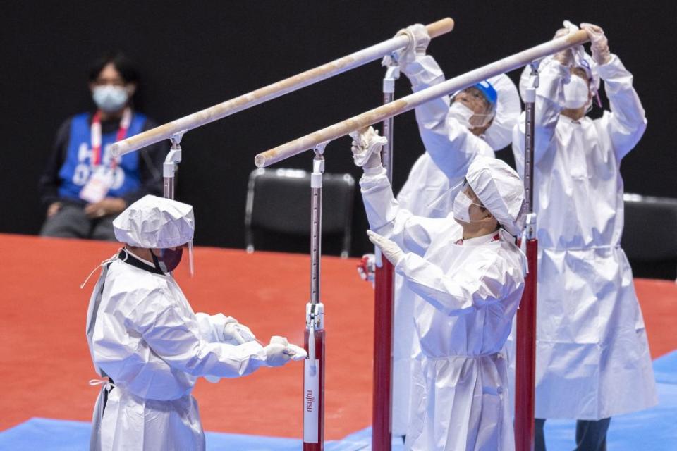 Staff members disinfect the parallel bars as a preventive measure against the Covid-19 coronavirus during the Artistic Gymnastics World Championships at the Kitakyushu City Gymnasium in Kitakyushu, Fukuoka prefecture.