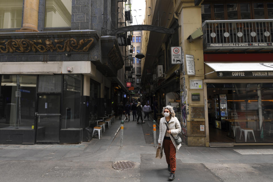 A woman wearing a face mask to help curb the spread of the coronavirus walks in Centre Place in Melbourne, Australia, Thursday, Nov. 5, 2020. Australia’s highest court has upheld a state’s border closure and dismissed a case arguing the pandemic measure was unconstitutional. The High Court judges ruled that Western Australia’s border closure to non-essential travel applied during “a hazard in the nature of a plague or epidemic” complied with the constitution. (James Ross/AAP Image via AP)