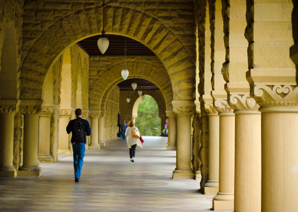 Stanford, United States - October 10, 2011: Students walk underneath a covered walkway at the Stanford University campus on their way to classes. Originally established in 1891, the university has over 15,000 students.