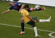 Ron Vlaar of the Netherlands kicks the ball near Australia's Tim Cahill (4) during their 2014 World Cup Group B soccer match at the Beira Rio stadium in Porto Alegre June 18, 2014. REUTERS/Marko Djurica (BRAZIL - Tags: SOCCER SPORT TPX IMAGES OF THE DAY WORLD CUP)