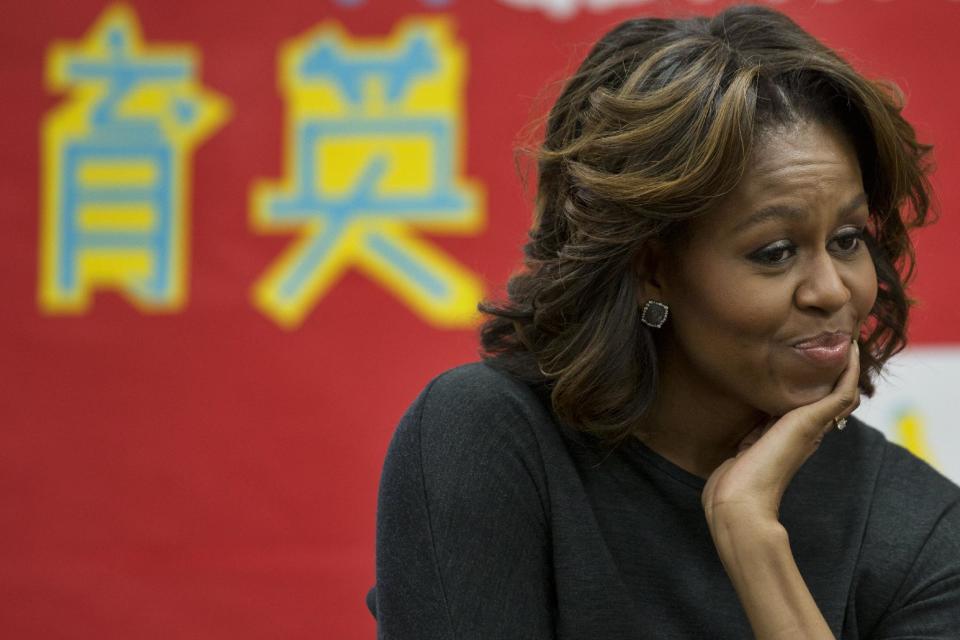 First lady Michelle Obama listens as a 6th grade class talks about a class trip they took to China, Tuesday, March 4, 2014, at Washington Yu Ying Public Charter School in Washington. The first lady is expected to take a trip to China along with her daughters and mother in March. (AP Photo/Jacquelyn Martin)