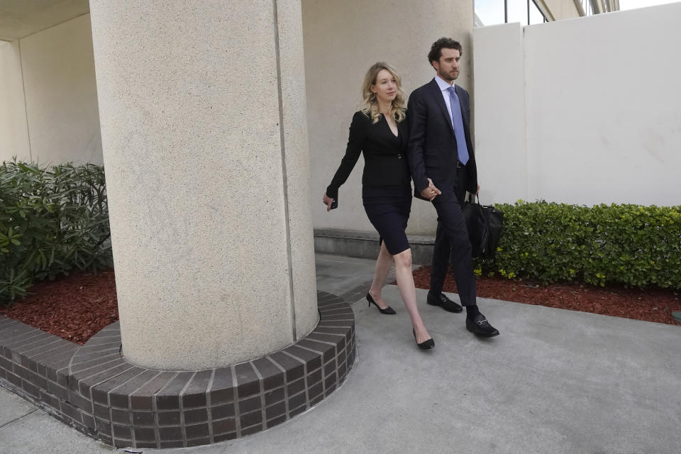 Former Theranos CEO Elizabeth Holmes, left, and her partner, Billy Evans, leave federal court in San Jose, Calif., Friday, March 17, 2023. (AP Photo/Jeff Chiu)