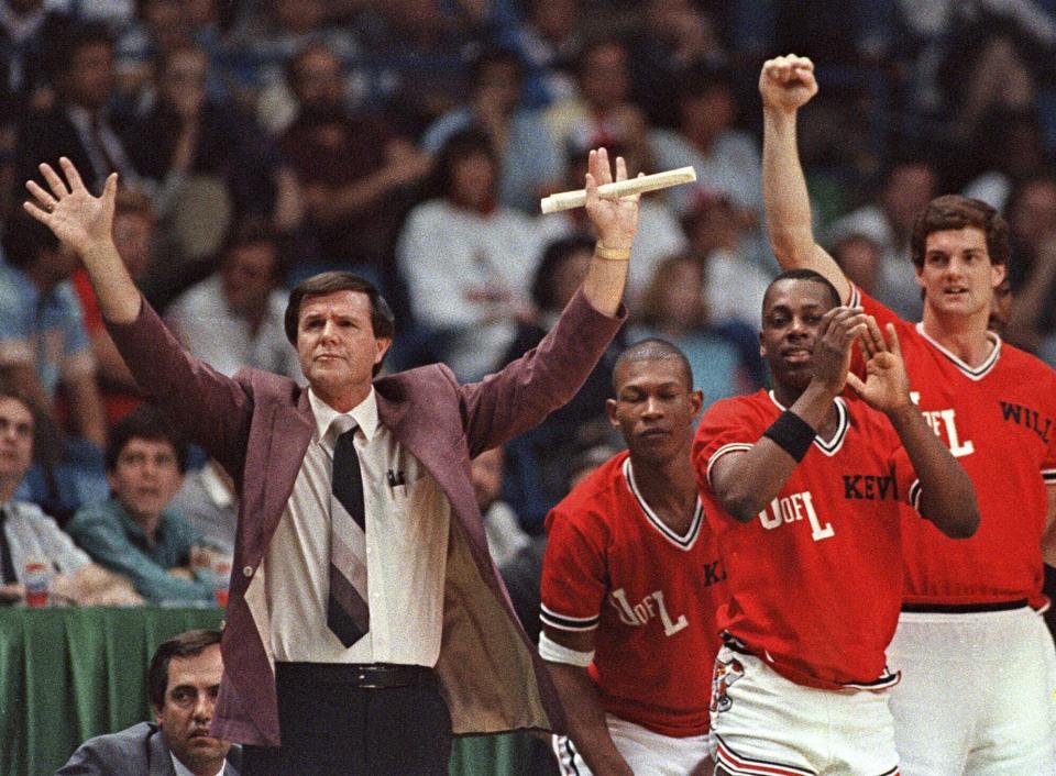 FILE - Louisville coach Denny Crum gestures towards his team as players from the bench begin to celebrate during the closing moments of their 88-77 victory over LSU in the NCAA college basketball semifinals in Dallas, March 29, 1986. Denny Crum, who won two NCAA men’s basketball championships and built Louisville into one of the 1980s’ dominant programs during a Hall of Fame coaching career, died Tuesday, May 9, 2023. He was 86. (AP Photo/David Longstreath, File)