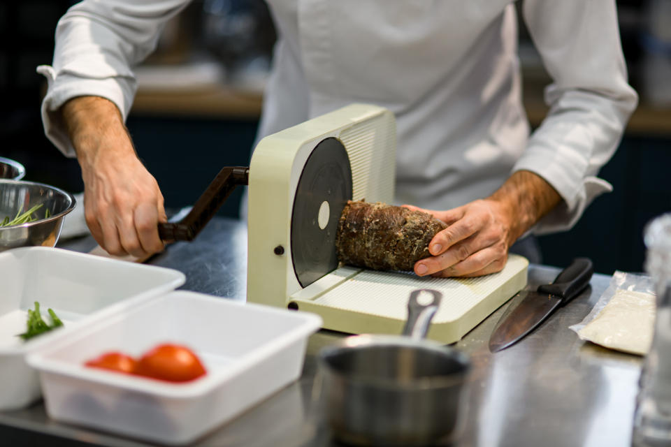 Person cutting a slab of meat