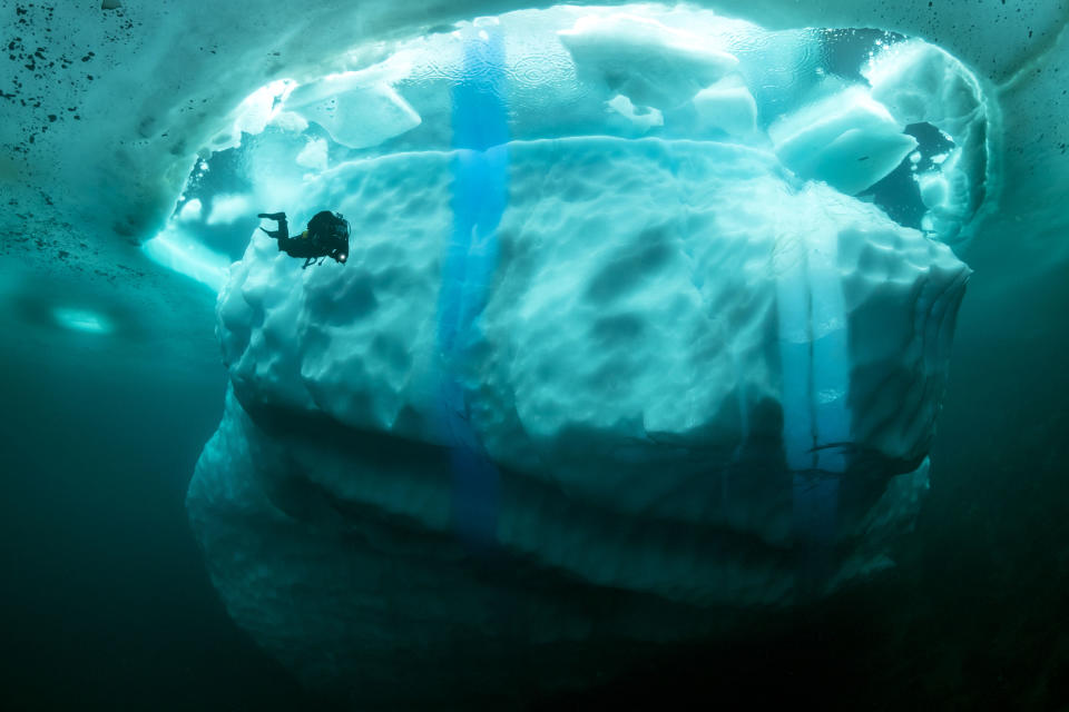 Stunning photos show ice dive beneath giant iceberg