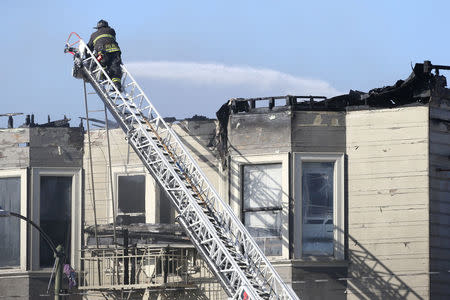 Firefighters battle a four-alarm blaze in a three-story apartment building in Oakland, California, U.S. March 27, 2017. REUTERS/Beck Diefenbach