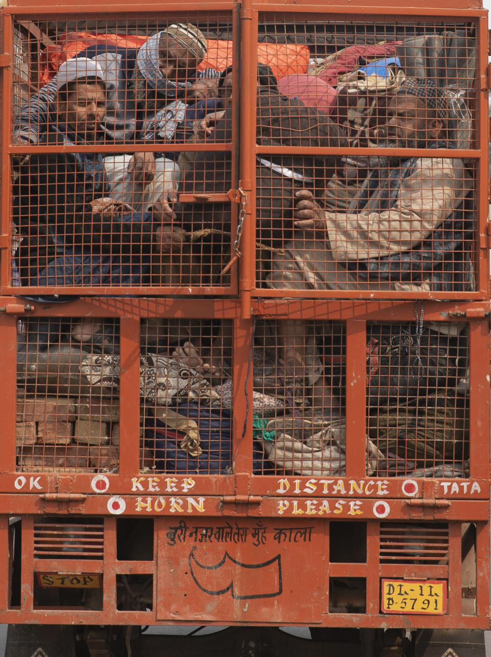 FILE - In this Wednesday, Feb. 26, 2020, file photo, a group of Muslims huddle together in the back of a mini truck and leave the area after Tuesday's violence in New Delhi, India. Indian police violated human rights during deadly religious riots over a controversial citizenship law in New Delhi earlier this year, Amnesty International said in a report released Friday, Aug. 28, 2020. It said police beat protesters, tortured detainees and in some cases took part in riots with Hindu mobs. (AP Photo/Rajesh Kumar Singh, File)