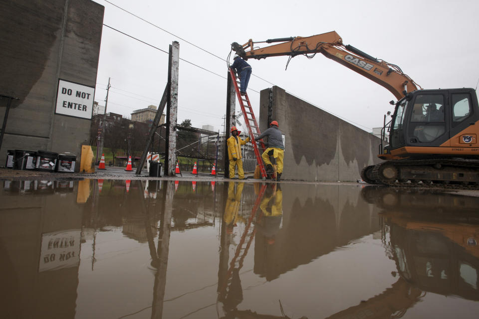 Workers with the City of Vicksburg start construction on one of the three flood wall gates on Levee Street in Vicksburg Miss., on Thursday Feb. 21, 2019. According to the National Weather Service the Mississippi River is currently at 44.69 feet and is expected to reach 48.9 feet. (Courtland Wells/The Vicksburg Post, via AP)